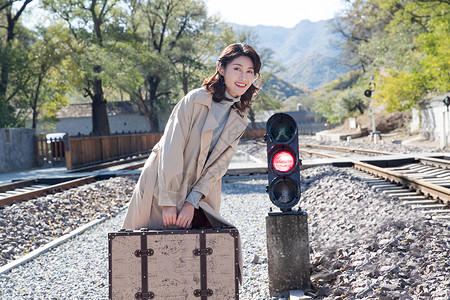 红灯拍照不看镜头放松环境青年女人走在铁轨上背景