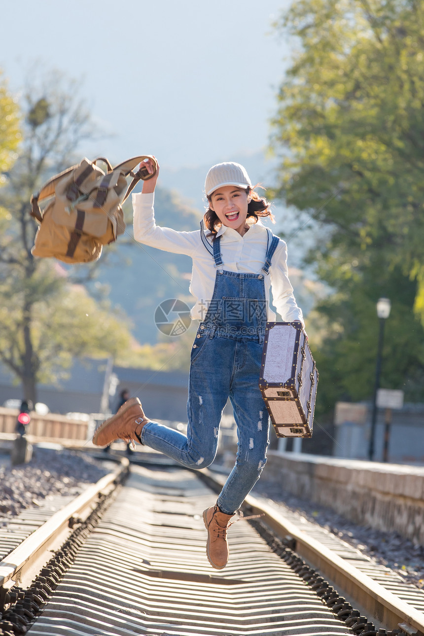 美女青年人徒步旅行青年女人在铁轨上跳跃图片