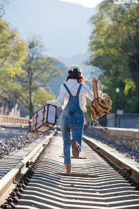 探险背包郊区青年女人在铁轨上行走图片