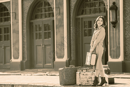 郊区快乐旅行箱青年女人站在火车站站台上图片