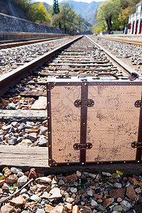 无人自由火车站铁轨旁边的旅行箱图片