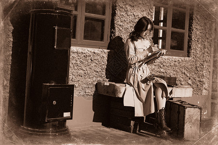 青年女人坐在火车站站台上看书高清图片