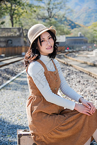 温馨放松交通青年女人坐在铁轨上图片