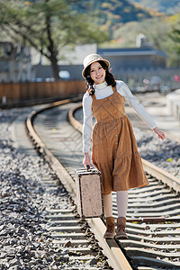 休闲青年女人在铁轨上行走图片