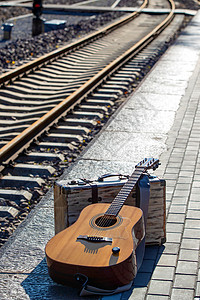 钏路火车站铁轨旁边的吉他和旅行箱背景