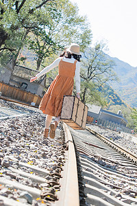旅途复古背影青年女人在铁轨上行走图片