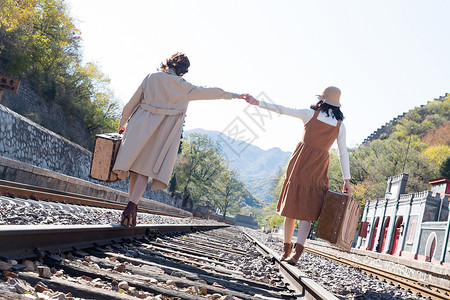 享乐友谊火车站青年闺蜜手牵手走在铁轨上图片