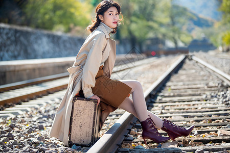 自由旅行者旅行者青年女人坐在铁轨上背景