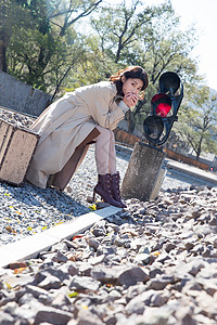 自由旅途青年女人坐在铁轨旁边图片