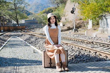 青年女人坐在铁轨上图片