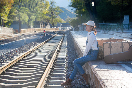 温馨怀旧日光青年女人在火车站站台上图片