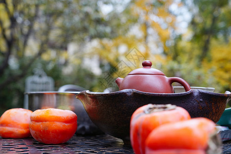 庭院桌子上的柿子和茶具高清图片