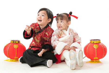 亚洲人拜年人兄妹两人穿新衣服坐在地上庆祝新年图片