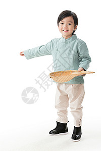 劳动赞歌元素新年前夕微笑影棚拍摄小男孩拿着簸箕撒谷物背景