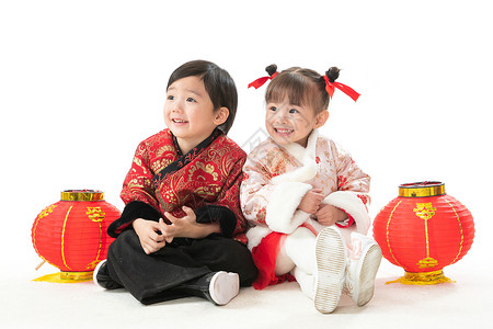 穿裙子的两个小姑娘气氛休闲活动并排兄妹两人穿新衣服坐在地上庆祝新年背景