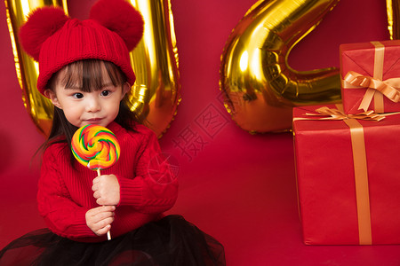 毛衣幸福愉悦可爱的小女孩吃棒棒糖图片