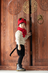 免抠木门花纹图案节日垂直构图可爱的小男孩站在大门口背景