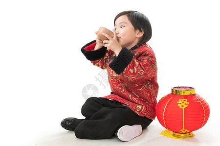 可爱的小男孩坐在地上喝水图片
