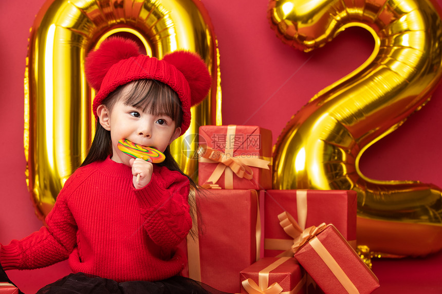 文化儿童快乐过新年的小女孩吃棒棒糖图片