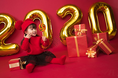 圣诞帽免抠幸福有趣的春节可爱的小女孩拿着棒棒糖背景