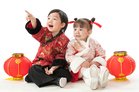 穿裙子的两个小姑娘乐趣欢乐春节兄妹两人穿新衣服坐在地上庆祝新年背景