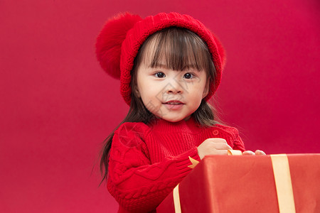 拿包的女孩亚洲无忧无虑春节可爱的小女孩拿新年礼物上背景