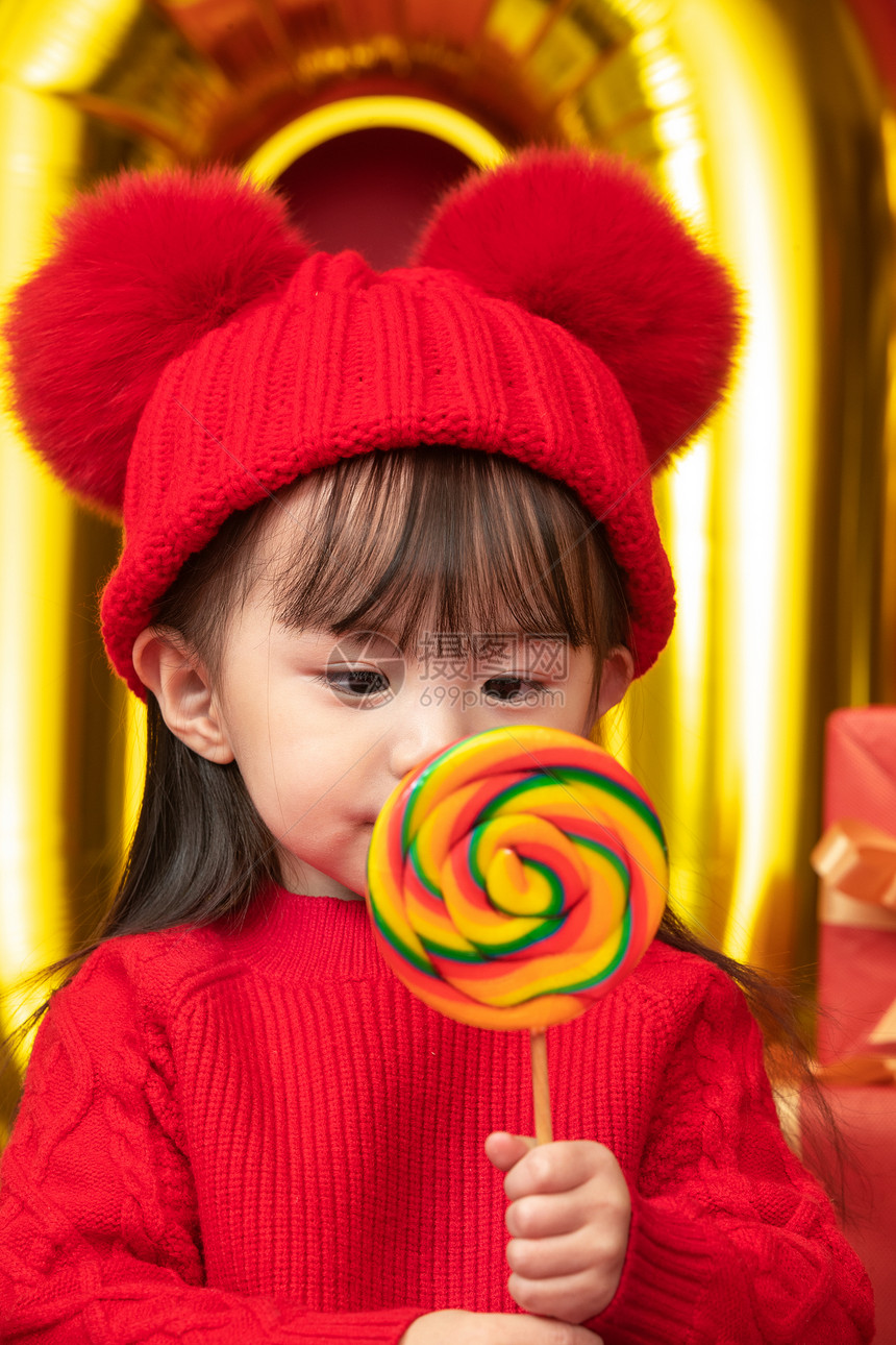 东亚毛衣儿童过新年的小女孩吃棒棒糖图片