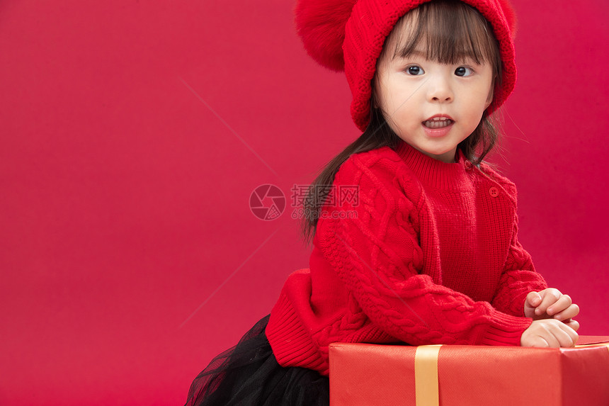 快乐微笑天真幸福的小女孩趴在礼物包装盒上图片
