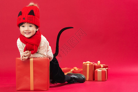 亚洲礼品祝福可爱的小男孩趴在新年礼物上玩耍图片