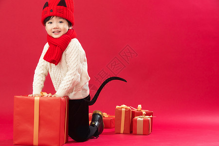 喜庆全身像可爱的小男孩趴在新年礼物上玩耍高清图片