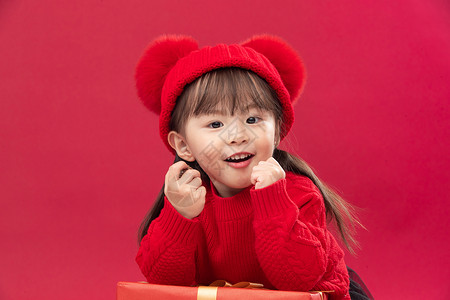 可爱彩色礼物快乐无忧无虑彩色图片可爱的小女孩趴在新年礼物上背景