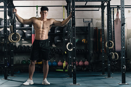 吊环运动城市生活短裤年轻男子在健身房健身背景