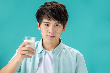 健康的露齿一笑注视镜头年轻男人喝牛奶高清图片