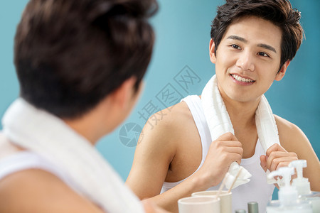 帅哥身体保养不看镜头快乐的年轻男人拿着毛巾照镜子图片