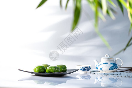 扇子茶壶和叶子面食竹子美食竹叶下的青团和茶具背景