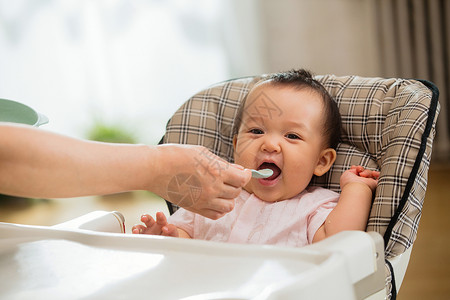 好奇女孩婴儿食品手臂椅子妈妈给宝宝喂饭背景