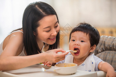 愉悦男孩居家年轻妈妈喂宝宝吃饭背景