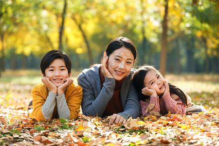 躺在叶子上男孩幸福家庭在户外玩耍背景