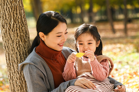 树叶环妈妈和女儿在户外玩耍背景