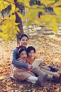 蹲在树下女孩妈妈和孩子在树下看书背景