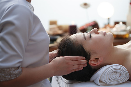 太阳穴按摩年轻女人在室内做SPA图片