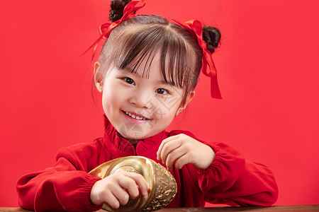 六一节日元素无忧无虑活力东亚小女孩拿着金元宝过新年背景
