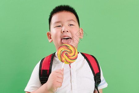 好好吃表情水平构图快乐好奇心可爱的小男孩拿着棒棒糖背景