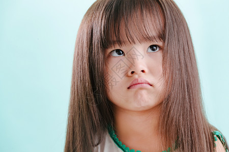 小孩愤怒表情包半身像水平构图长发小女孩生气的可爱表情背景