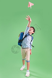 背书包的小学生扔纸飞机高清图片