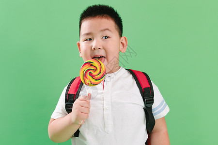 表情纯洁胖子可爱的小男孩拿着棒棒糖图片