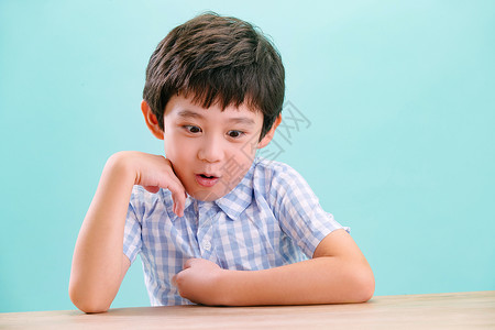 好奇心渴望惊奇小男孩的可爱表情手托下巴高清图片素材