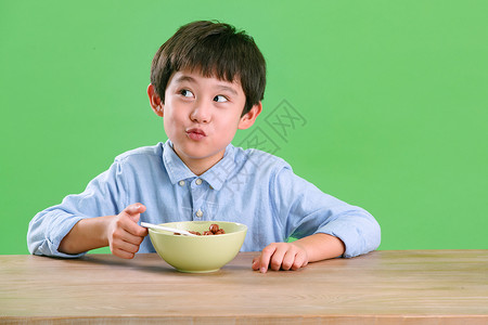 害羞超级碗表情可爱的小男孩吃东西背景