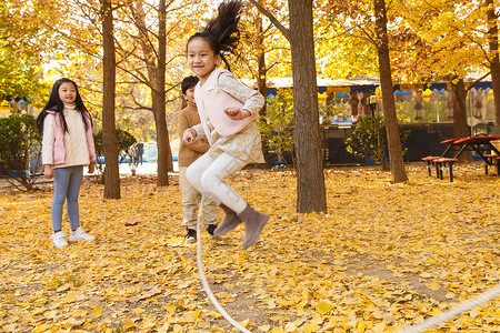 跳绳小朋友银杏树男孩女孩在户外玩耍背景