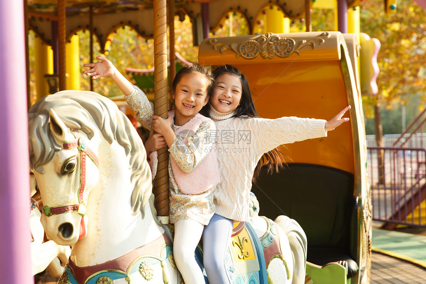 游乐园两个小女孩在玩旋转木马图片
